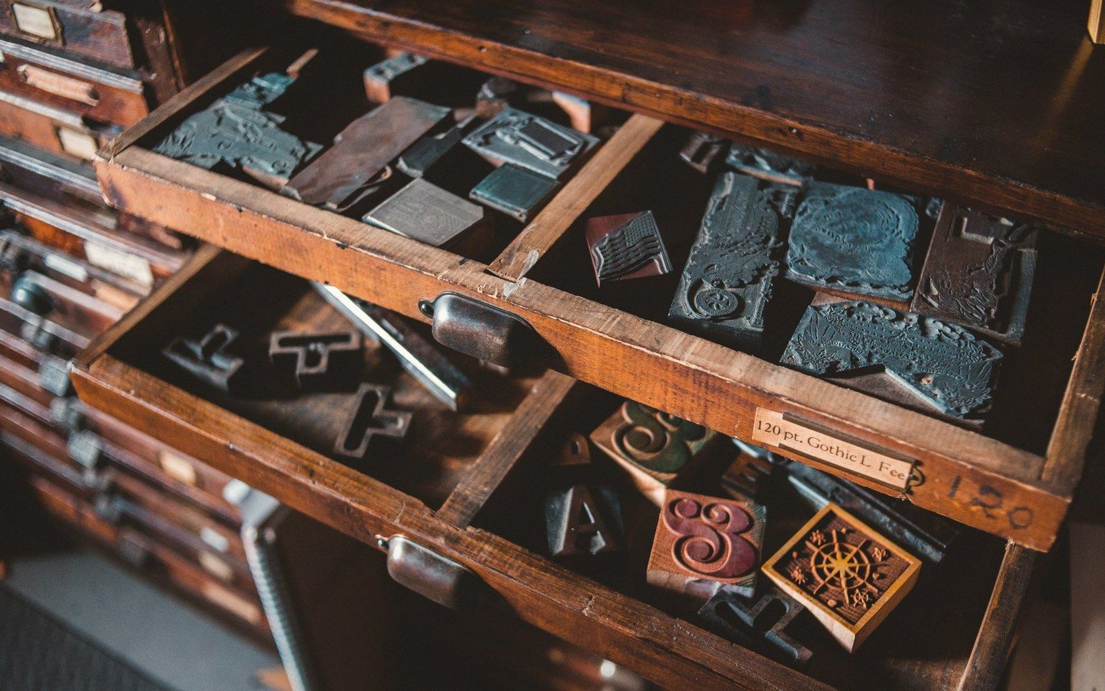 A compositor's tray of type beside printed cards